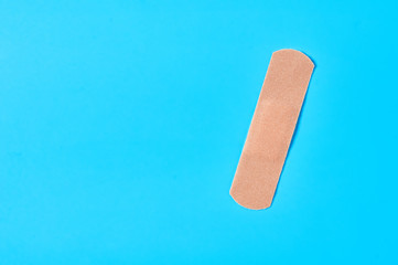Sticky medical patch on blue background. Healthcare concept