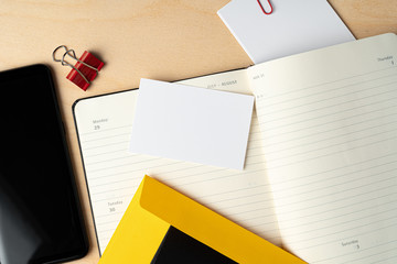 Mock up of blank business card and black smartphone screen on table, close up