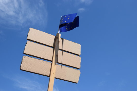 Protestschild mit Europaflagge vor blauem Himmel