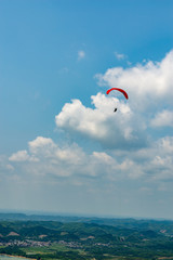Outdoor city green hill scenery and paragliding
