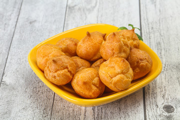 Sweet tasty profiteroles heap in the bowl