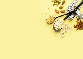 Two spoons of different sizes are filled with oatmeal and golden flax, raisins, almonds, pumpkin seeds. Healthy breakfast, proper nutrition, diet.