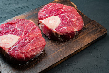 Raw beef fillet steaks on wooden background, close up.