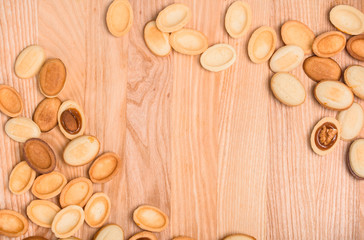 Homemade Russian nuts with condensed milk on a light pink background, wafer napkin. Cut nuts with condensed milk. Bitten goodies for coffee. Condensed Nuts. Flat lay