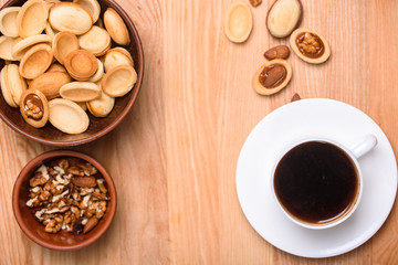 Homemade Russian nuts with condensed milk on a light pink background, wafer napkin. Cut nuts with condensed milk. Bitten goodies for coffee. Condensed Nuts. Flat lay