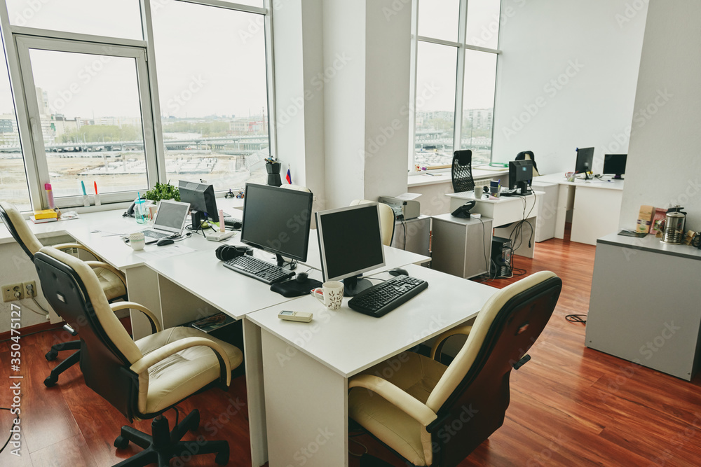 Poster interior of empty modern office with desktop computers on tables placed near each other, coronavirus
