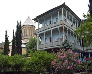 View of authentic georgian balcony and a church in the garden in old tbilisi