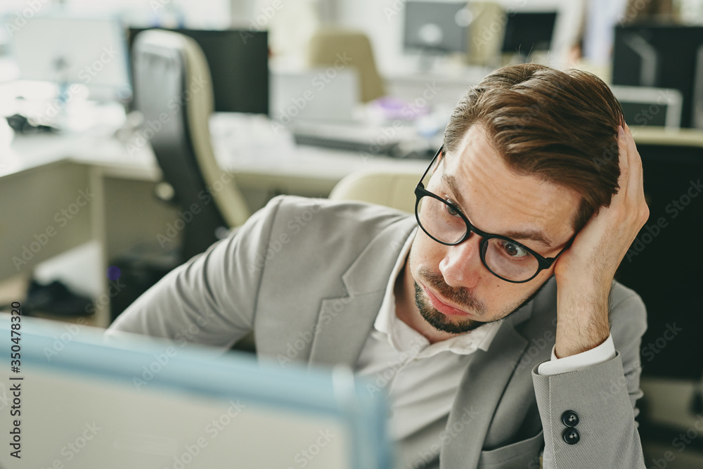 Aufkleber stressed young businessman in glasses working alone in office and looking at bad sales statistics on
