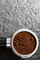 Filter holder for espresso coffee machine with coffee powder in detail. Italian espresso and fresh grinded coffee beans