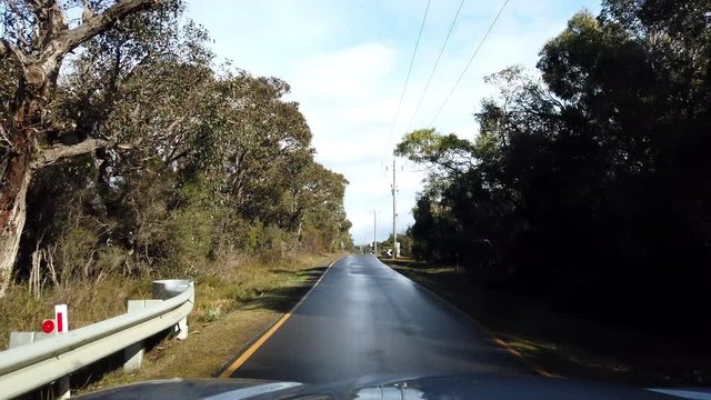 Narrow road in the bush of Australia, only fits one car, seen from vehicle, slow