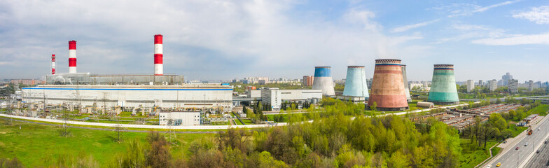 Fototapeta na wymiar power plant pipes and cooling towers on the background of the panorama of the Moscow city against blue sky. Biryulyovo district in the south of Moscow