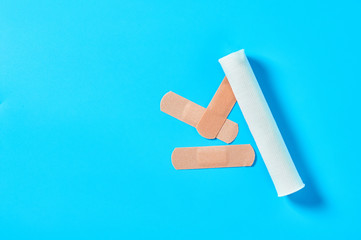 Heap of sticky medical patch near bandage on blue background. Healthcare concept
