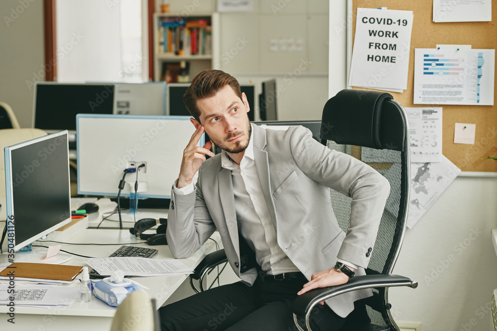 Aufkleber young bearded businessman being upset about business problems sitting at desk and looking away in em