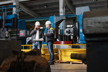 Fototapeta na wymiar Two young engineers at a modern factory. The photo illustrates new technologies and production.