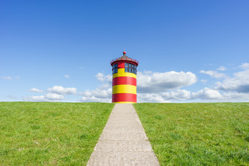 Bunt angemalter Leuchtturm bei Pilsum an der deutschen Nordseeküste