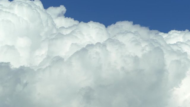 White clouds swirl against the blue sky closeup.