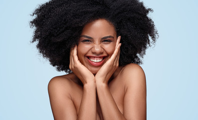 Cheerful black model with hands on cheeks