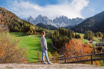 Girl enjoying the view of mountain peaks of Santa Maddalena in Val di Funes, South Tyrol, Italy