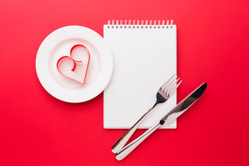 Paper heart shape on plate with notebook for valentines day