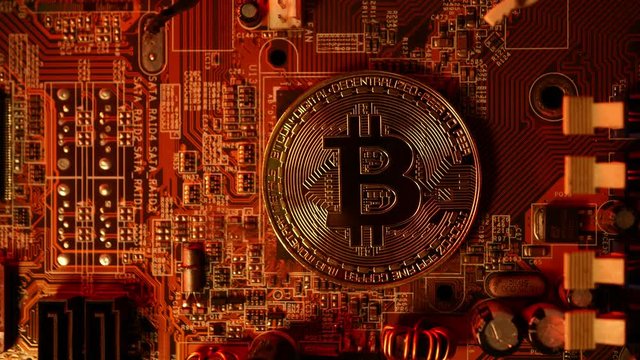 Golden coins with bitcoin symbol on a main board computer.	