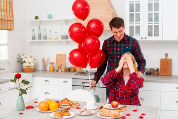 Medium shot man surprising woman with balloons