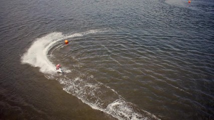 Aerial of Jet ski's racing making turns around a buoy of the race course