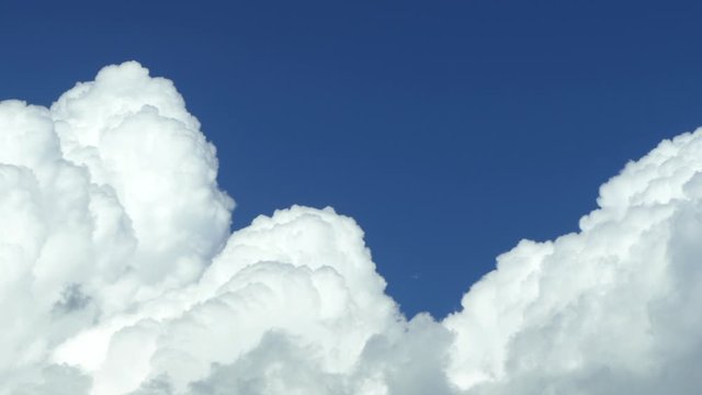 White clouds swirl against the blue sky closeup.