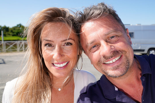 happy couple at the beach make selfie in sea coast vacation