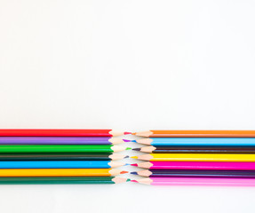 color pencils facing each other on white background