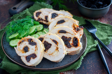 Chicken roll with prunes with fresh cucumbers and herbs, selective focus