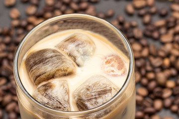 Coffee ice cubes in glass with milk.