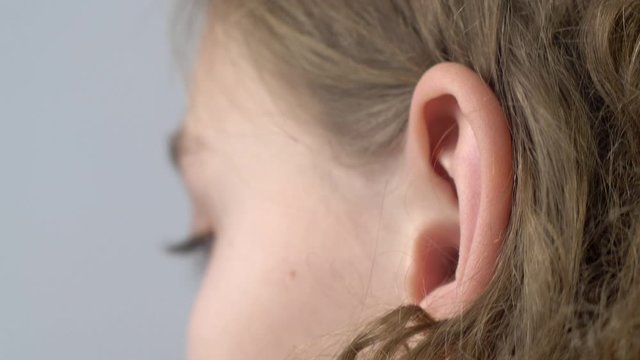Ear of young girl. Close up view of human ear. Hearing concept