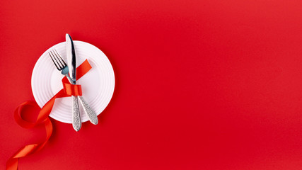 Top view of cutlery on plate with ribbon and copy space