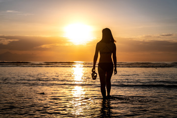 Fototapeta na wymiar diver girl on the beach at sunset