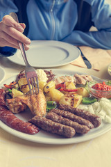 Detail of female hand picking food from the plate. Y