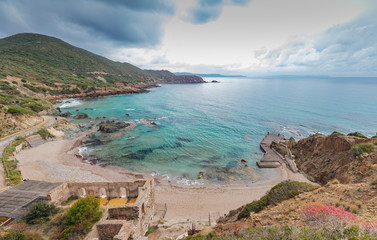 Masua beach with walls of old mining buildings.South Sardinia