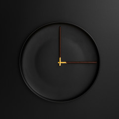 Dark plate with chocolate sticks in form of a clock