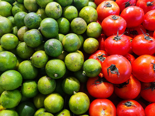 Green lemons with red tomatoes, contrast color
