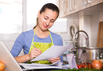 Woman working with papers and laptop