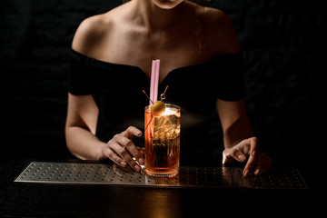 old-fashioned glass with ready-made fresh bright cold alcoholic cocktail stands on bar.
