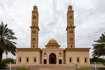 Fototapeta na wymiar Sultan Qaboos Mosque in Bahla, Oman with two minarets against clouded sky