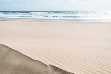 Sandy beach and the ocean waves of Costa Da Caparica, Portugal.