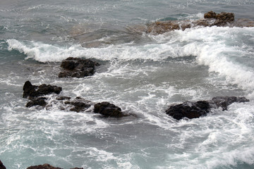 small waves at the stones, crashing with foam
