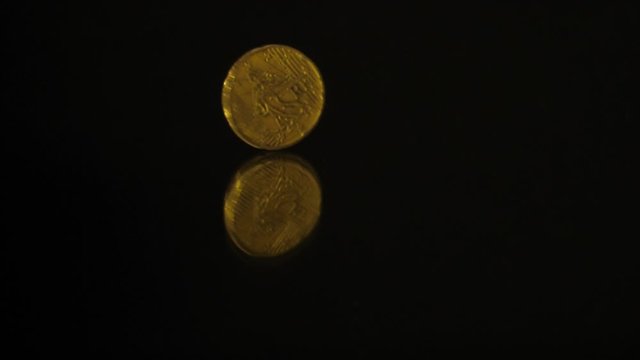 20 Euro cents Coin is rotating on a black mirror