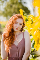 red hair girl in the field of sunflowers