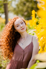 red hair girl in the field of sunflowers