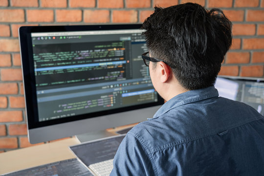 Young Professional programmer working at developing programming and website working in a software develop company office, writing codes and typing data code, Programming with HTML, PHP and javascript