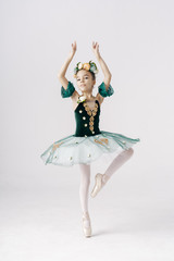Beautiful preteen girl ballerina wearing a princess dress, spring or summer fairy dancing over white background