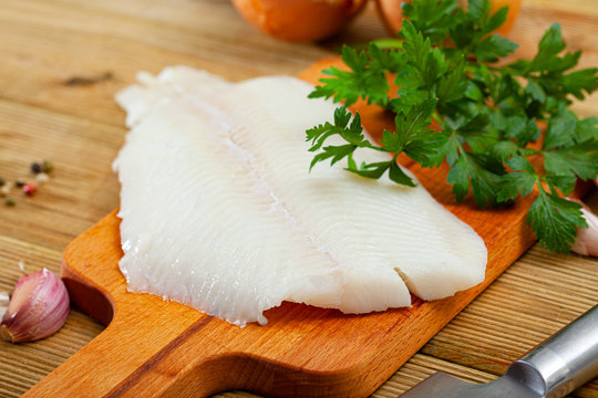 Raw halibut fillet on wooden table
