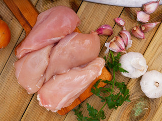 Raw chicken fillets and condiments